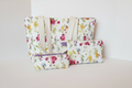 Wildflower Garden Quilted Travel Bundle featuring a matching white canvas tote bag with magenta and yellow flowers, a boxy cosmetic case, and a flat wallet pouch against a clean white background.