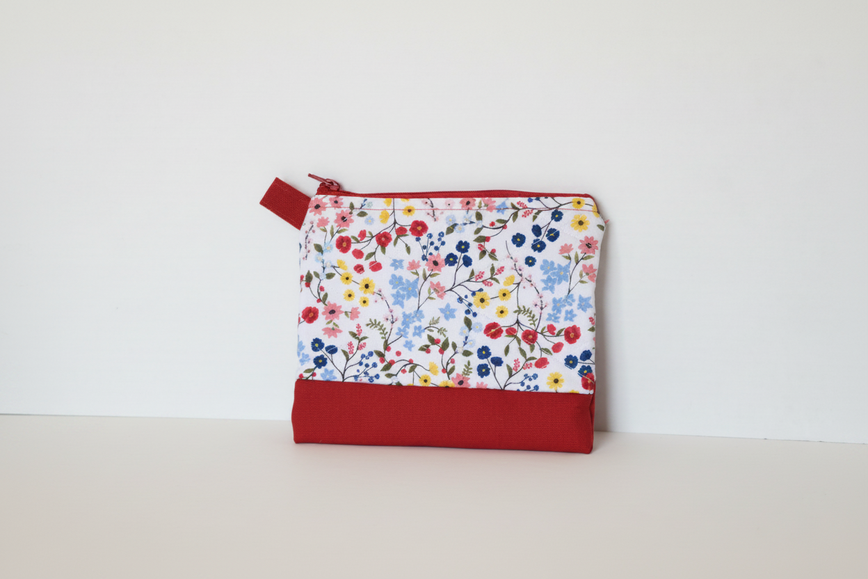 Handmade crimson red floral quilted mini wallet with botanical wildflower print, artisan fabric card holder with vertical quilting and red zipper.