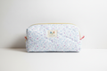 Handmade meadow blossom floral quilted cosmetic pouch with delicate blue vines, pink accents, and signature KIALIYAH label.