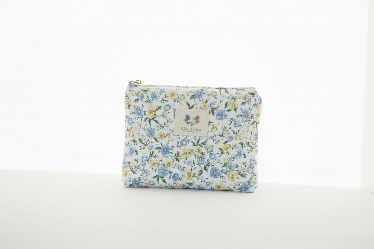 Handmade bluebell print quilted mini wallet with blue and yellow wildflowers, artisan fabric card holder with vertical quilting and gold zipper.