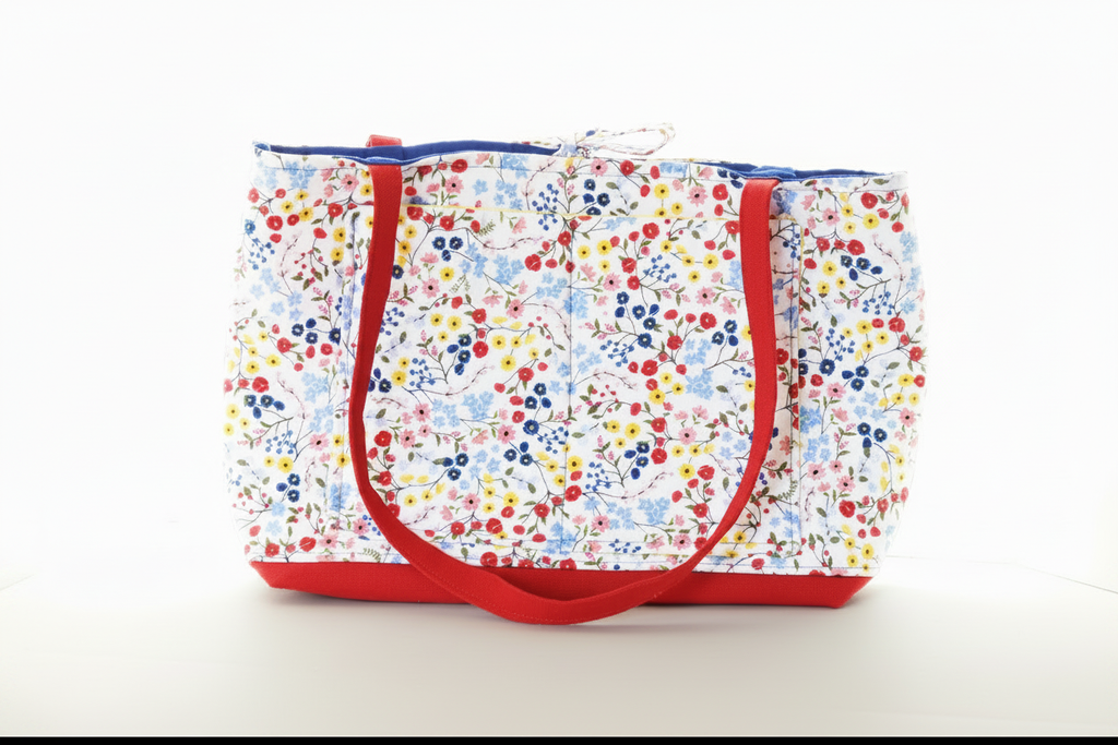 Floral-patterned tote bag with red handles on a white background