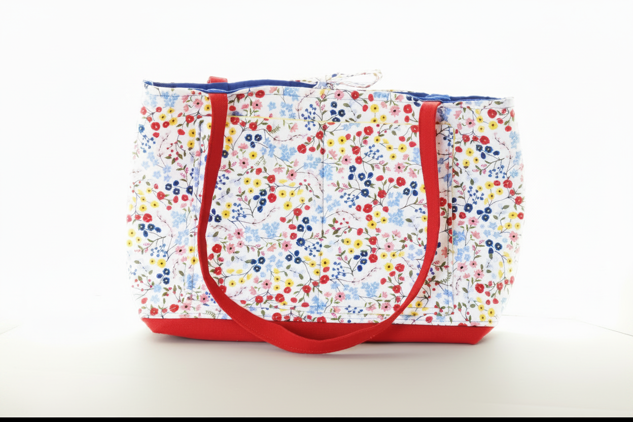 Floral-patterned tote bag with red handles on a white background