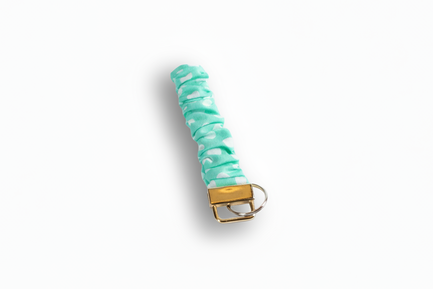 Turquoise scrunchie with gold clasp on a white background