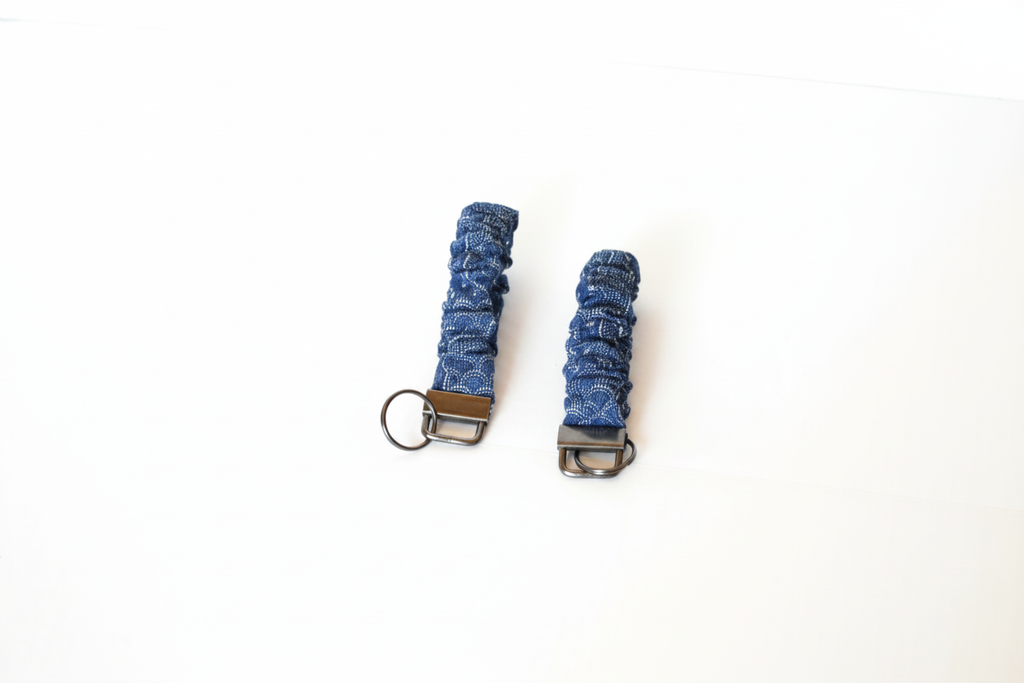 Two blue keychains with metal clasps on a white background