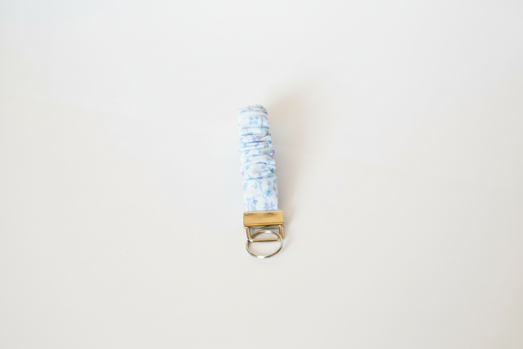 Keychain with a blue and white patterned strap on a light gray background