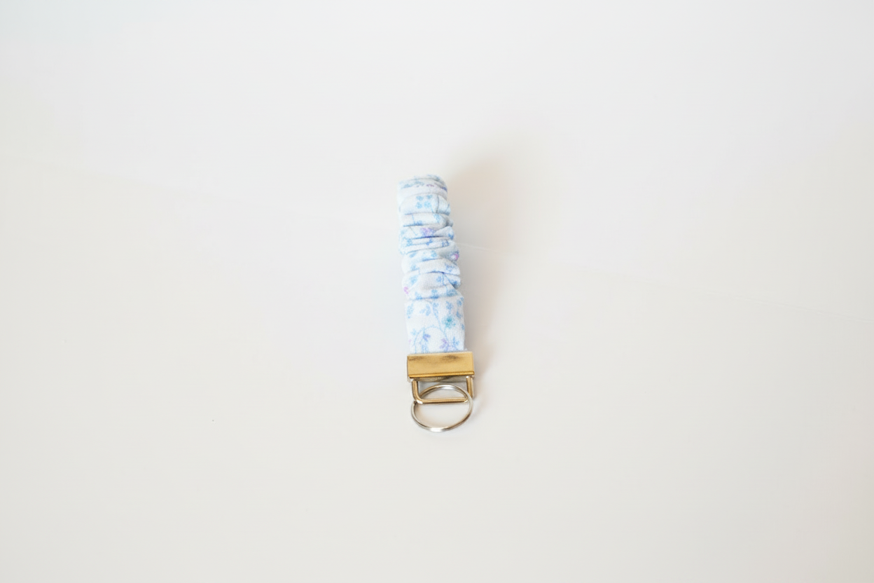 Keychain with a blue and white patterned strap on a light gray background