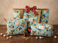 The Terracotta Songbird Quilted Bundle  showcasing the large quilted tote bag with a terracotta-rust bow, the rectangular makeup bag, and the zipper wallet pouch together on a wooden table.