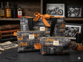 Highway Classic Quilted Travel Bundle featuring a matching charcoal plaid motorcycle print tote bag with an orange bow, boxy cosmetic case, and flat zipper pouch on a slate board.