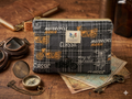Highway Classic Quilted Wallet canvas zipper pouch featuring a charcoal plaid vintage motorcycle print with an orange polka dot hardware loop flat on a wooden workbench next to a brass compass.