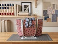 Handcrafted 3-pocket diamond-quilted tote bag featuring a red-and-white stripe and navy star pattern, a large navy-and-white gingham center fabric tie bow, and cream webbed shoulder straps lined with polka-dot ribbon.